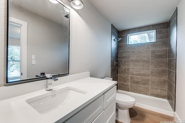 1071 Diamondhead Dr, Canyon Lake, TX 78133 - bathroom featuring toilet, vanity, tiled shower, and wood finished floors