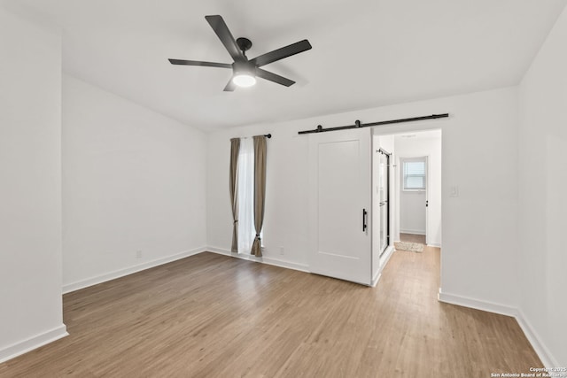2718 Old Field Dr Unit 101, San Antonio, TX 78247 - empty room featuring ceiling fan, light wood-style floors, a barn door, and baseboards