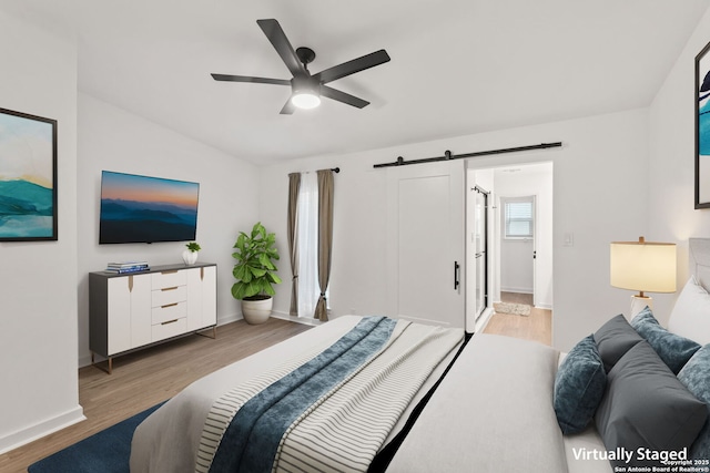 2718 Old Field Dr Unit 101, San Antonio, TX 78247 - bedroom featuring light wood finished floors, a barn door, baseboards, and a ceiling fan