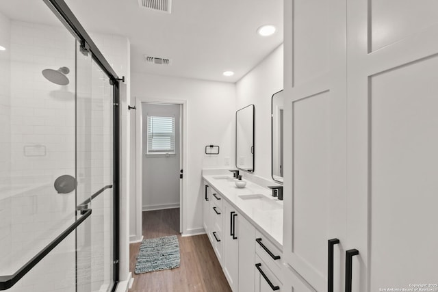 2718 Old Field Dr Unit 101, San Antonio, TX 78247 - bathroom with a shower stall, double vanity, wood finished floors, recessed lighting, and baseboards