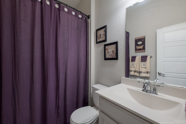 2415 Olive Way, San Antonio, TX 78259 - full bathroom with a textured wall, toilet, vanity, and curtained shower