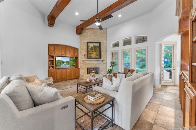 1015 Campanile, San Antonio, TX 78258 - living room with beamed ceiling, ceiling fan, a fireplace, arched walkways, and a towering ceiling