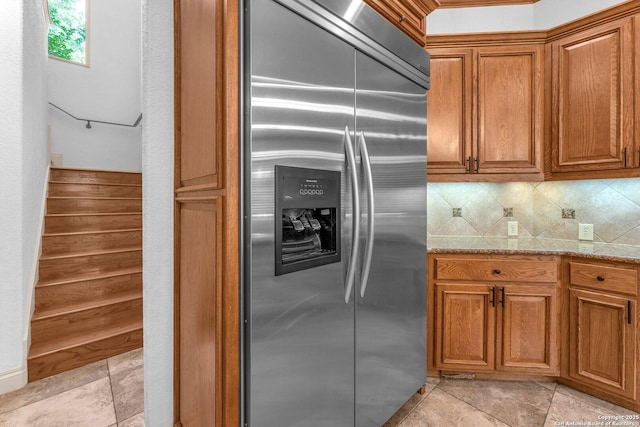 1015 Campanile, San Antonio, TX 78258 - kitchen featuring stainless steel fridge with ice dispenser, brown cabinets, decorative backsplash, and light stone countertops
