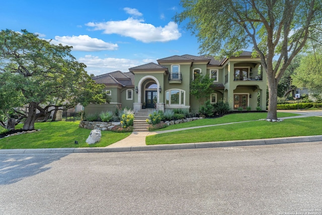 1015 Campanile, San Antonio, TX 78258 - mediterranean / spanish house featuring french doors, a balcony, a front yard, and stucco siding