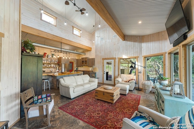 231 Doris Dr, Kerrville, TX 78028 - living area with a towering ceiling, wood walls, stone flooring, and beam ceiling
