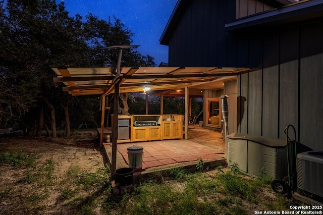 231 Doris Dr, Kerrville, TX 78028 - deck at twilight featuring a pergola, central AC, and a patio area