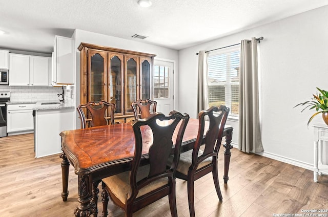 324 Washita Riv, Cibolo, TX 78108 - dining area with light wood-type flooring and a textured ceiling