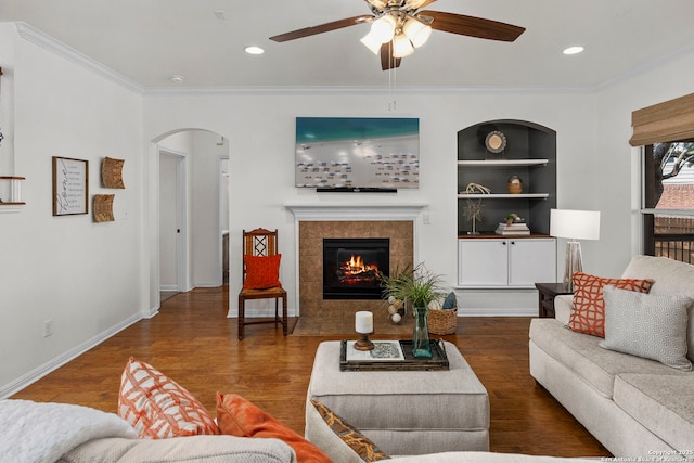 18719 Needle Rock, San Antonio, TX 78258 - living area featuring arched walkways, ceiling fan, wood finished floors, ornamental molding, and a tiled fireplace