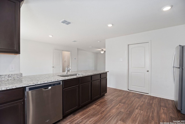 11042 Eyelet Hbr, Converse, TX 78109 - kitchen featuring appliances with stainless steel finishes, a sink, a peninsula, dark wood-type flooring, and dark brown cabinetry