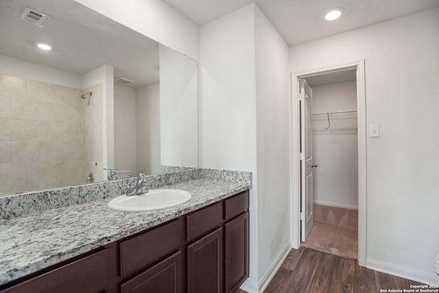 11042 Eyelet Hbr, Converse, TX 78109 - full bathroom featuring wood finished floors, vanity, a tile shower, a spacious closet, and baseboards