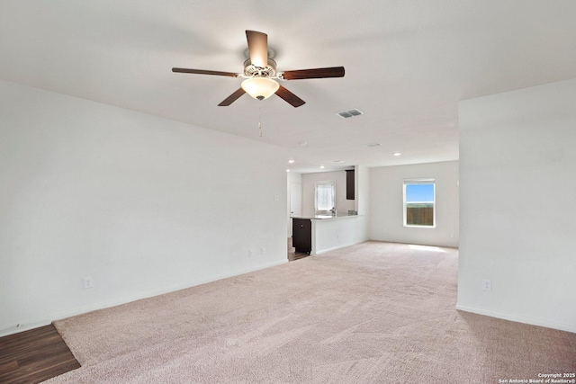 11042 Eyelet Hbr, Converse, TX 78109 - unfurnished living room with ceiling fan, light carpet, and baseboards