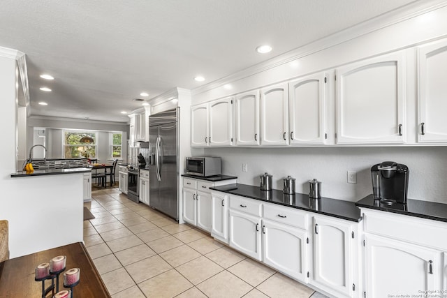 1946 Encino Belle, San Antonio, TX 78259 - kitchen with stainless steel appliances, light tile patterned flooring, white cabinetry, recessed lighting, and dark countertops