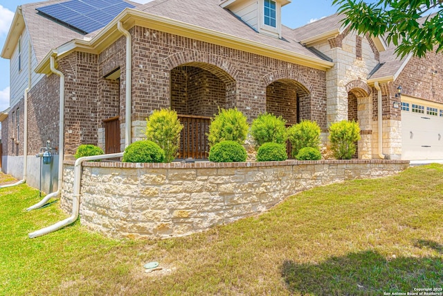 12827 Sabinal Riv, San Antonio, TX 78253 - view of home's exterior featuring brick siding, a lawn, roof mounted solar panels, and an attached garage