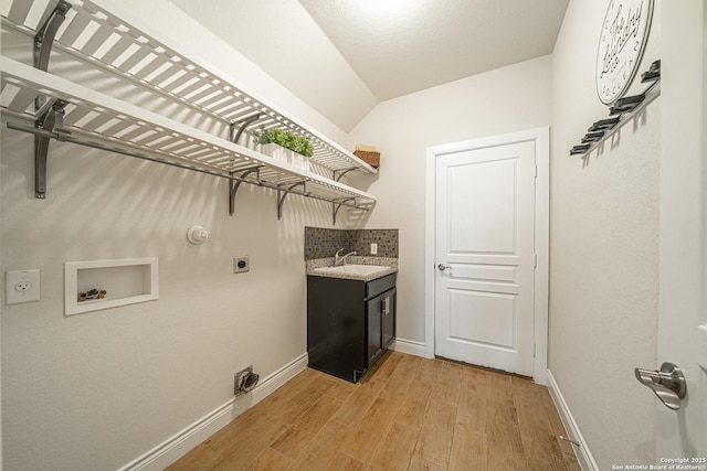 12827 Sabinal Riv, San Antonio, TX 78253 - washroom with washer hookup, hookup for an electric dryer, bar with sink, baseboards, and light wood-type flooring
