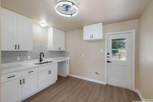142 W Palfrey, San Antonio, TX 78223 - kitchen featuring a sink, light wood-style flooring, decorative backsplash, light countertops, and baseboards