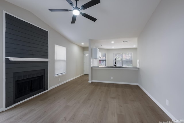 6723 Hickory Springs Dr, San Antonio, TX 78249 - unfurnished living room featuring wood finished floors, a ceiling fan, a fireplace, recessed lighting, and vaulted ceiling