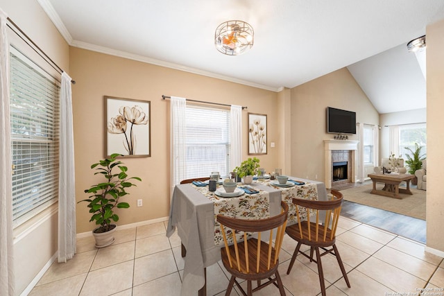 20519 View Mdw, San Antonio, TX 78258 - dining room featuring light tile patterned floors, a tiled fireplace, baseboards, ornamental molding, and vaulted ceiling