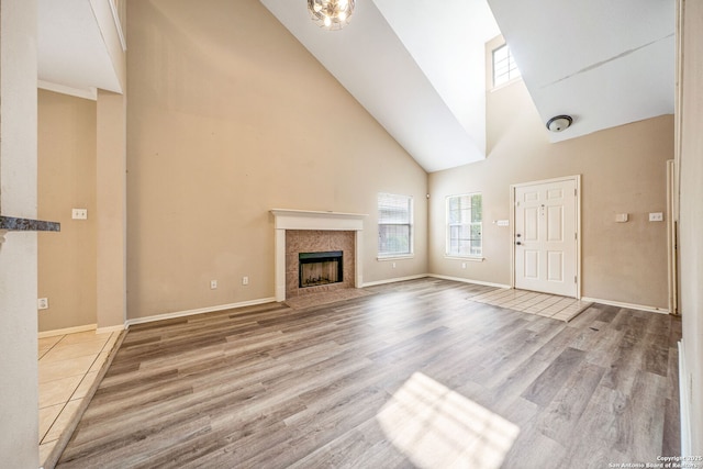20519 View Mdw, San Antonio, TX 78258 - unfurnished living room with a tile fireplace, high vaulted ceiling, wood finished floors, and baseboards