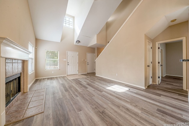 20519 View Mdw, San Antonio, TX 78258 - unfurnished living room with high vaulted ceiling, a tile fireplace, wood finished floors, and baseboards