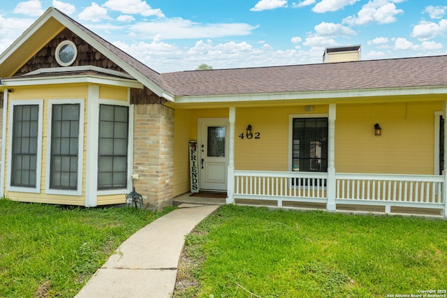 402 Teakwood, Victoria, TX 77901 - view of exterior entry featuring a lawn, a porch, and a shingled roof