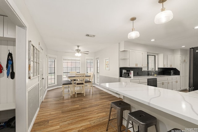 402 Teakwood, Victoria, TX 77901 - kitchen featuring black appliances, open shelves, wood finished floors, white cabinets, and a breakfast bar area