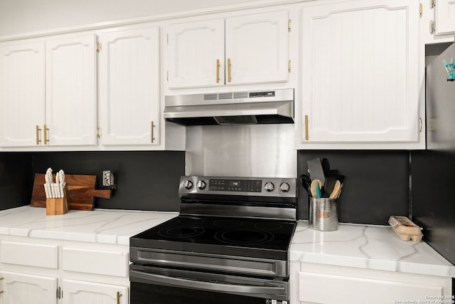 402 Teakwood, Victoria, TX 77901 - kitchen with under cabinet range hood, stainless steel electric stove, white cabinets, and light stone countertops