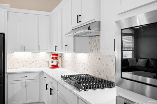 529 Huntwick, Boerne, TX 78006 - kitchen with stainless steel gas cooktop, under cabinet range hood, decorative backsplash, light countertops, and white cabinets