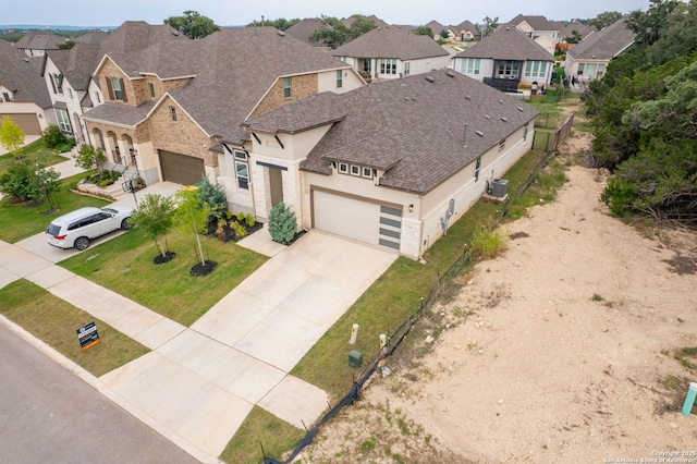 529 Huntwick, Boerne, TX 78006 - view of front facade featuring roof with shingles, stucco siding, central AC unit, a residential view, and driveway