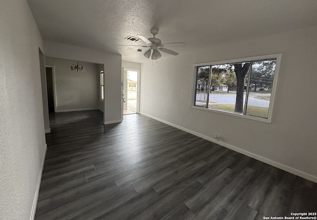 102 Killarney Dr, San Antonio, TX 78223 - spare room featuring a ceiling fan, baseboards, dark wood-style flooring, a chandelier, and a textured ceiling