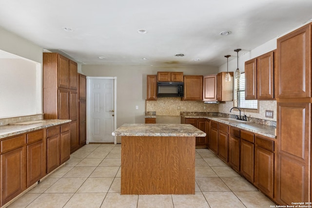 4503 Tropical, San Antonio, TX 78218 - kitchen with black microwave, a sink, a kitchen island, brown cabinetry, and decorative backsplash
