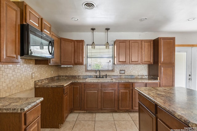4503 Tropical, San Antonio, TX 78218 - kitchen featuring black microwave, a sink, brown cabinetry, dark countertops, and pendant lighting