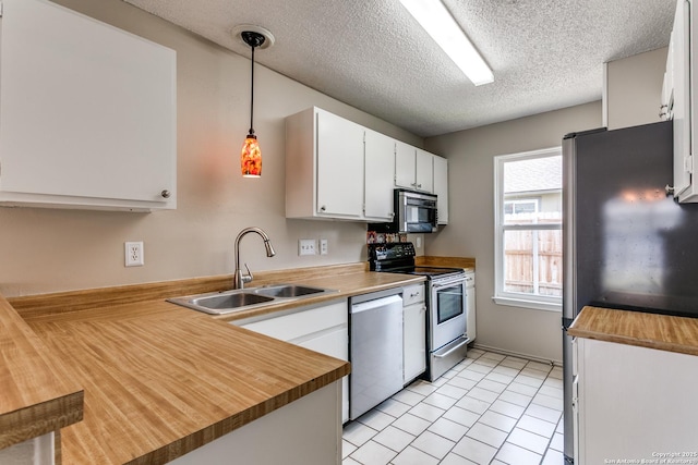 12215 Ridge Smt, San Antonio, TX 78247 - kitchen with appliances with stainless steel finishes, a sink, white cabinetry, a textured ceiling, and a peninsula