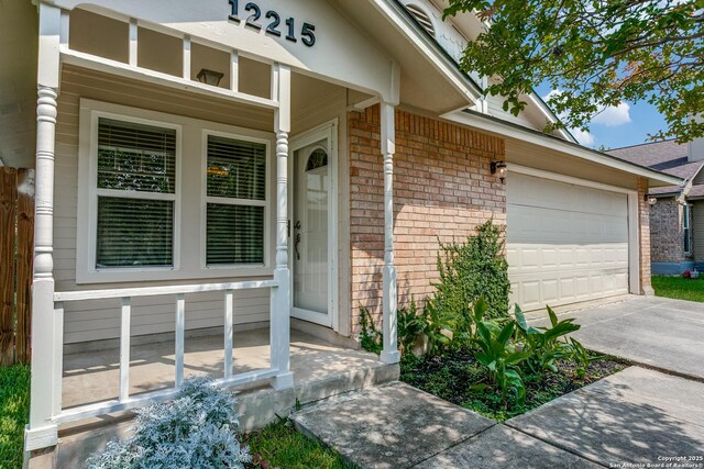 12215 Ridge Smt, San Antonio, TX 78247 - property entrance with brick siding, concrete driveway, and a garage