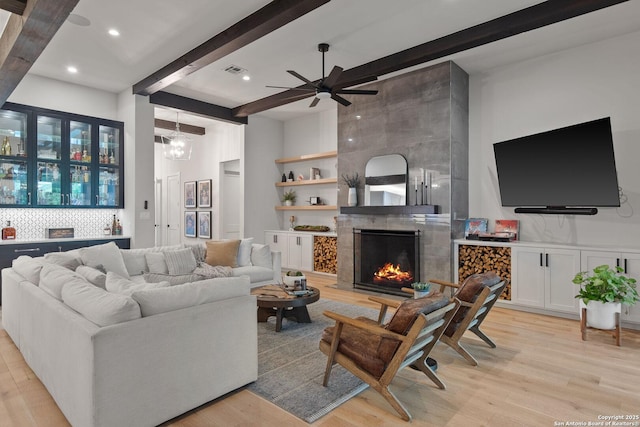 312 Frey, Boerne, TX 78006 - living area featuring beam ceiling, light wood-style flooring, ceiling fan, a tile fireplace, and a high ceiling
