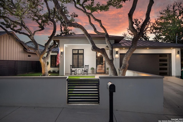 312 Frey, Boerne, TX 78006 - view of front of house with a fenced front yard, a porch, concrete driveway, an attached garage, and a standing seam roof