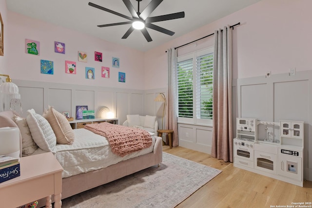 312 Frey, Boerne, TX 78006 - bedroom with a decorative wall, wood finished floors, a wainscoted wall, and ceiling fan