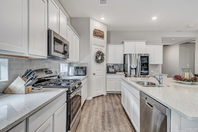 8922 Trail Dust, San Antonio, TX 78254 - kitchen with appliances with stainless steel finishes, a sink, light wood-style floors, white cabinetry, and recessed lighting