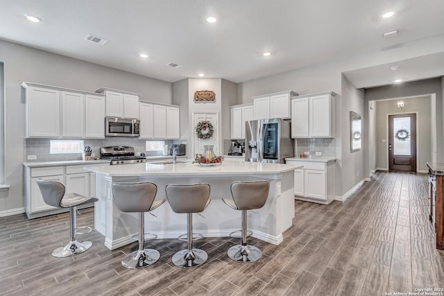 8922 Trail Dust, San Antonio, TX 78254 - kitchen featuring stainless steel appliances, a kitchen bar, light wood-type flooring, a kitchen island with sink, and recessed lighting