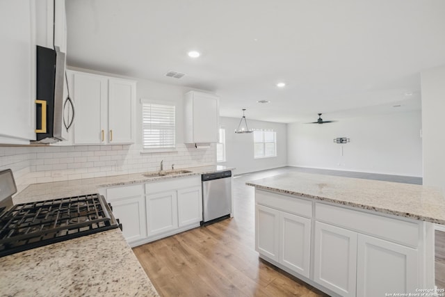21902 Backspin, San Antonio, TX 78261 - kitchen with appliances with stainless steel finishes, a sink, tasteful backsplash, white cabinetry, and light stone counters