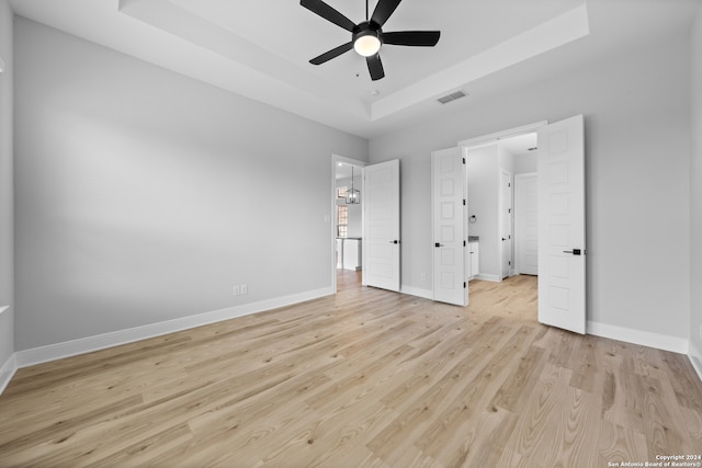 190 Azalea Aly, Castroville, TX 78009 - unfurnished bedroom with a raised ceiling, light wood-type flooring, baseboards, and ceiling fan