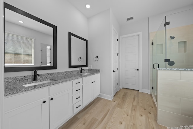 190 Azalea Aly, Castroville, TX 78009 - bathroom featuring a stall shower, double vanity, wood finished floors, baseboards, and recessed lighting