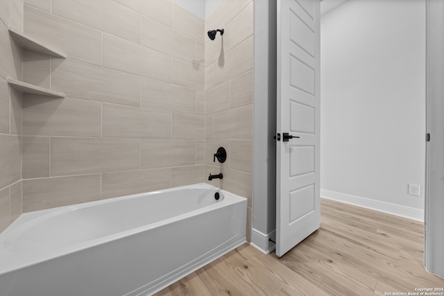 190 Azalea Aly, Castroville, TX 78009 - bathroom with baseboards, wood finished floors, and washtub / shower combination
