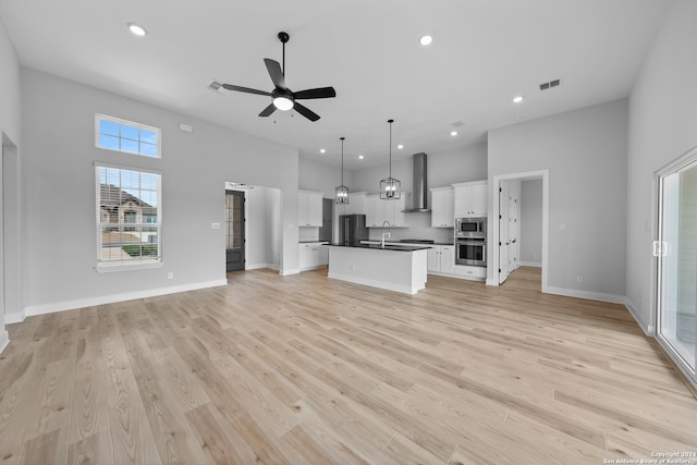 190 Azalea Aly, Castroville, TX 78009 - unfurnished living room with a ceiling fan, a high ceiling, recessed lighting, light wood-type flooring, and a sink