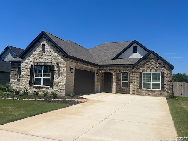 204 Azalea Aly, Castroville, TX 78009 - view of front of house featuring board and batten siding, concrete driveway, a garage, brick siding, and roof with shingles