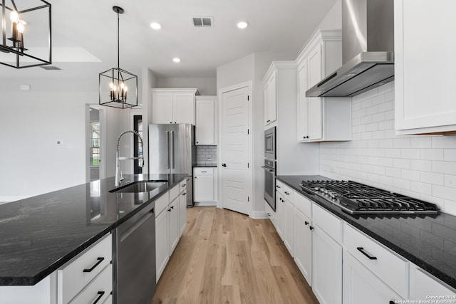 204 Azalea Aly, Castroville, TX 78009 - kitchen with wall chimney range hood, stainless steel appliances, a sink, a chandelier, and white cabinetry