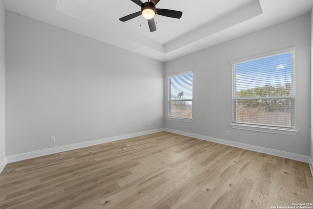 204 Azalea Aly, Castroville, TX 78009 - unfurnished room featuring a tray ceiling, light wood finished floors, ceiling fan, and baseboards
