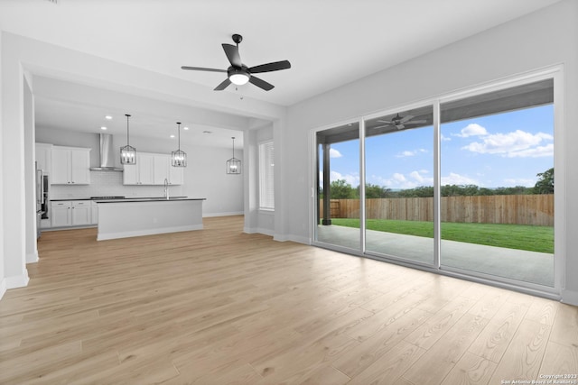 174 Azalea Aly, Castroville, TX 78009 - unfurnished living room with a ceiling fan, light wood finished floors, a sink, recessed lighting, and baseboards