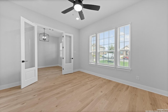 159 Azalea Aly, Castroville, TX 78009 - empty room featuring a chandelier, baseboards, light wood-style flooring, and a ceiling fan