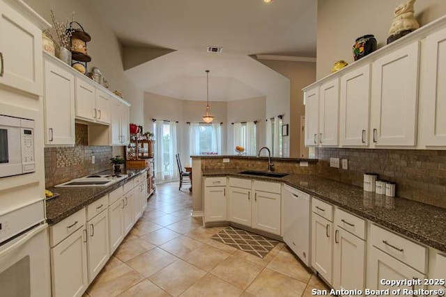 228 Long Crk, New Braunfels, TX 78130 - kitchen with a sink, white appliances, decorative backsplash, a peninsula, and white cabinetry