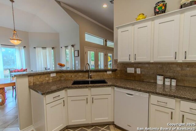 228 Long Crk, New Braunfels, TX 78130 - kitchen featuring dishwasher, a sink, a peninsula, light tile patterned floors, and tasteful backsplash